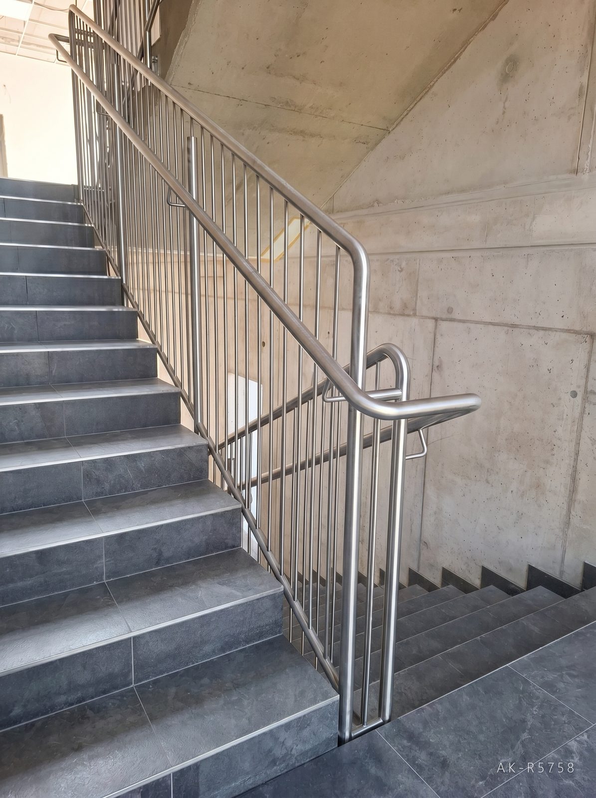 Nerezové zábradlí ve škole v Dačicích. Doplňuje strohou betonovou architekturu stavby, foto 5/7