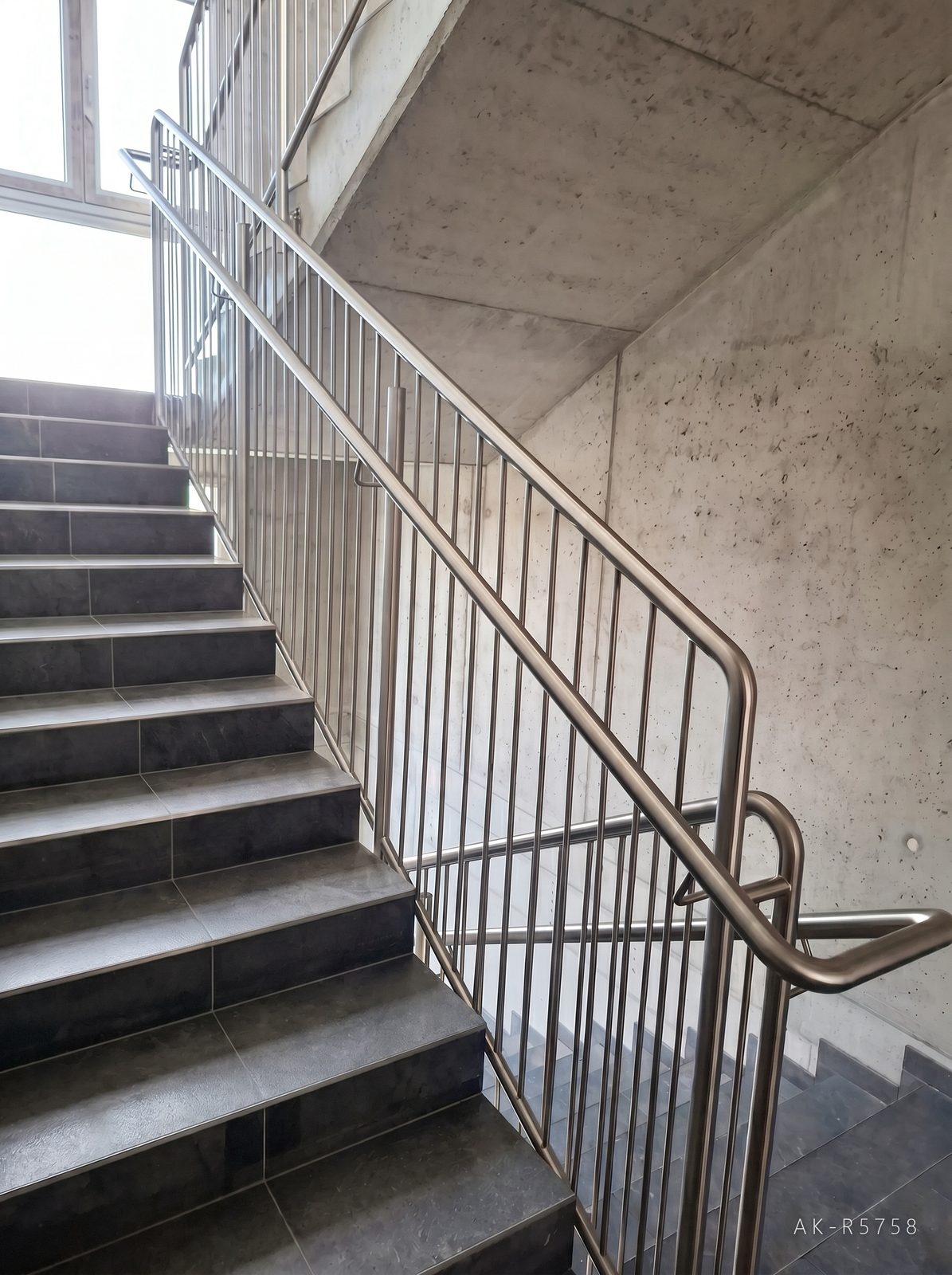Nerezové zábradlí ve škole v Dačicích. Doplňuje strohou betonovou architekturu stavby, foto 6/7
